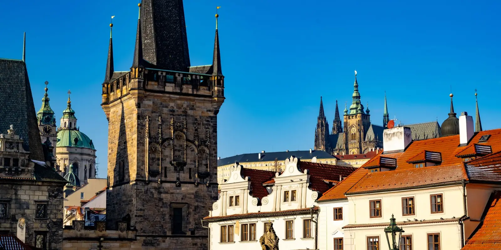 Capture of Prague's historic skyline featuring St. Vitus Cathedral and medieval towers under a clear blue sky.