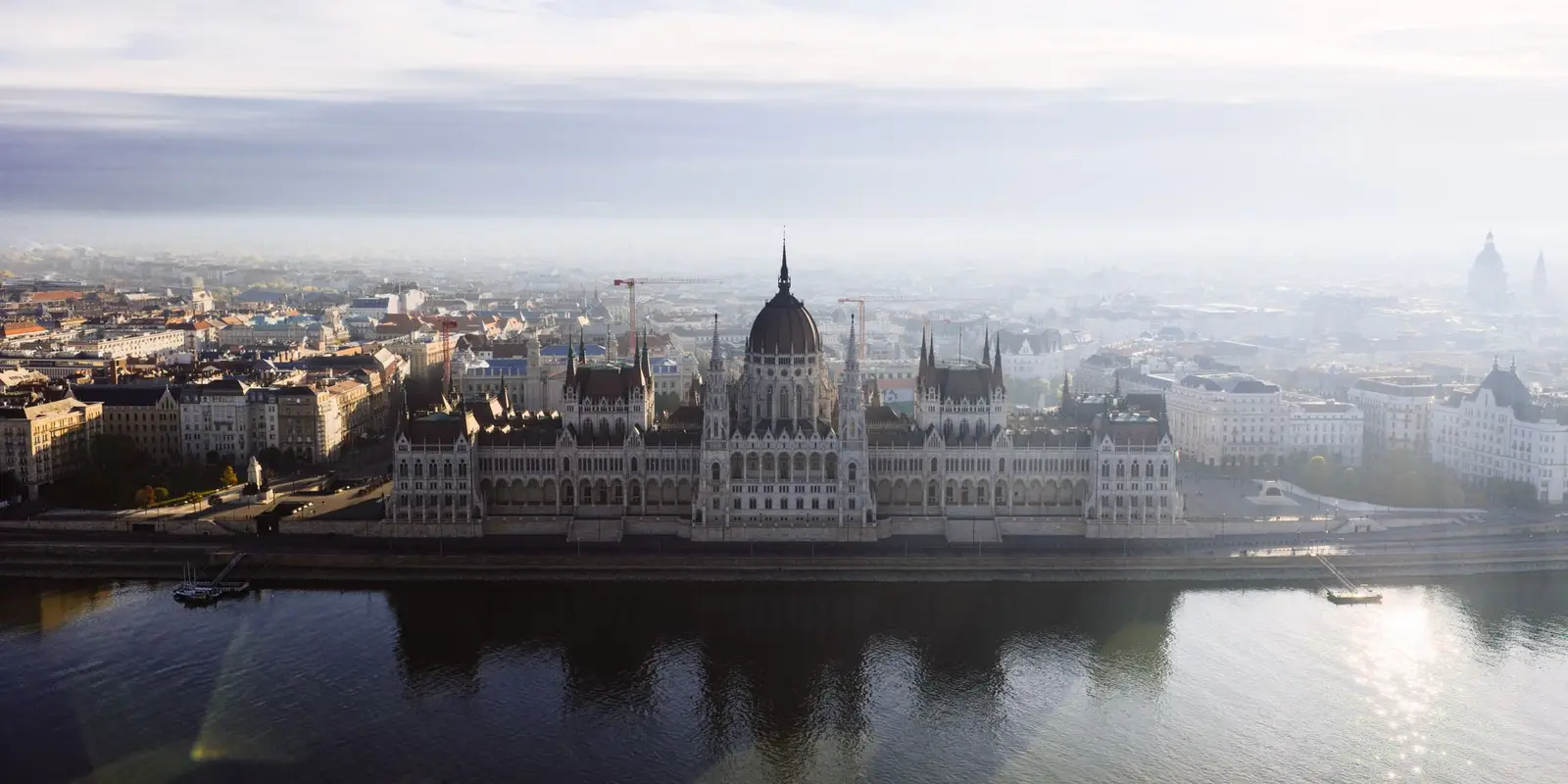 Stunning aerial photo of Budapest's iconic Parliament Building on a misty day.