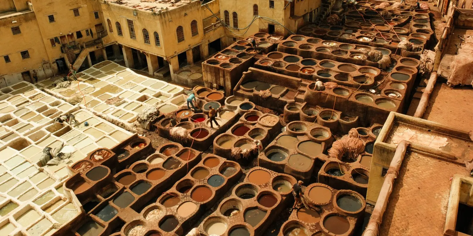 Aerial view of the historic leather tannery in Fes, Morocco, showcasing traditional dyeing vats.