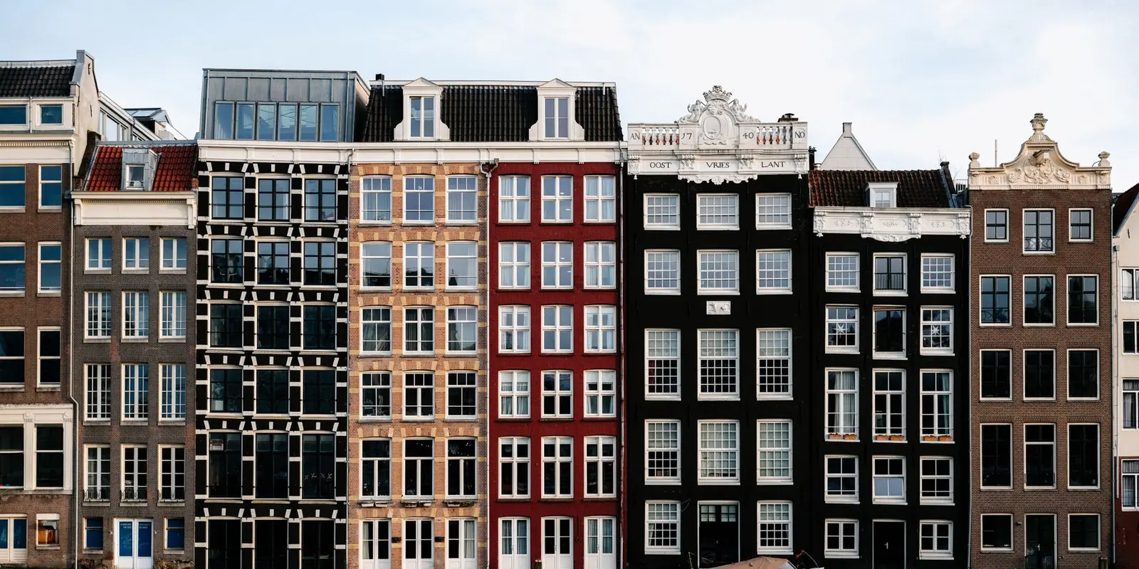 Row of colorful canal houses by the water in Amsterdam, Netherlands.