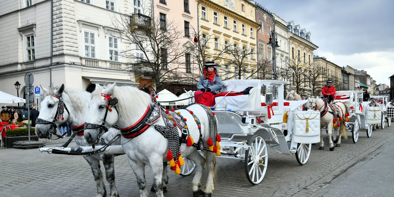 Beautiful horse-drawn carriages on a historic street in Kraków, Poland, perfect capturing the old town charm.
