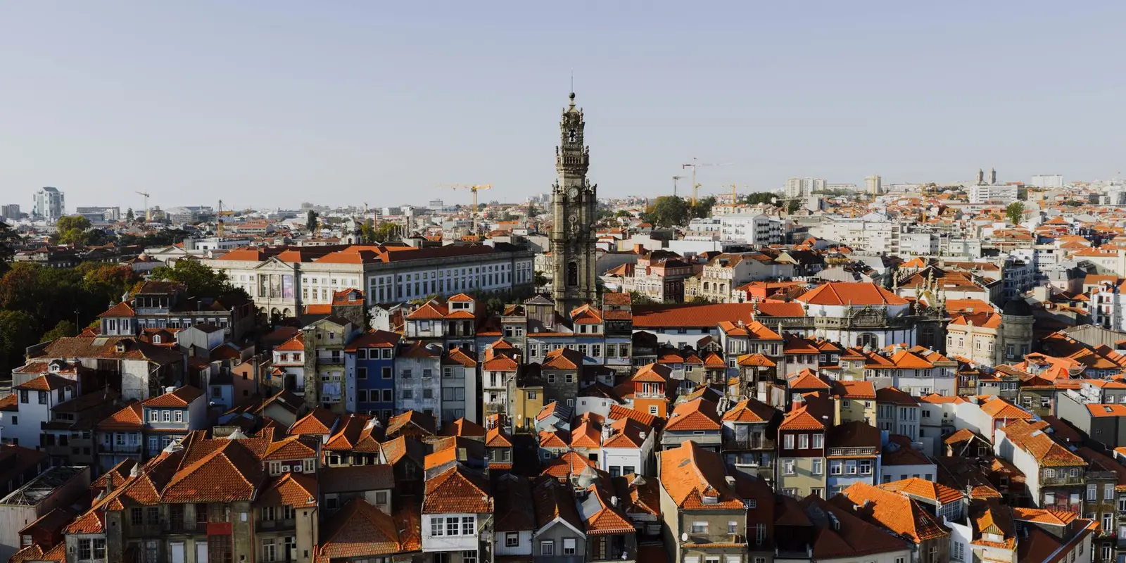 A beautiful aerial view of Porto, Portugal, highlighting the iconic Clerigos Tower at sunset.