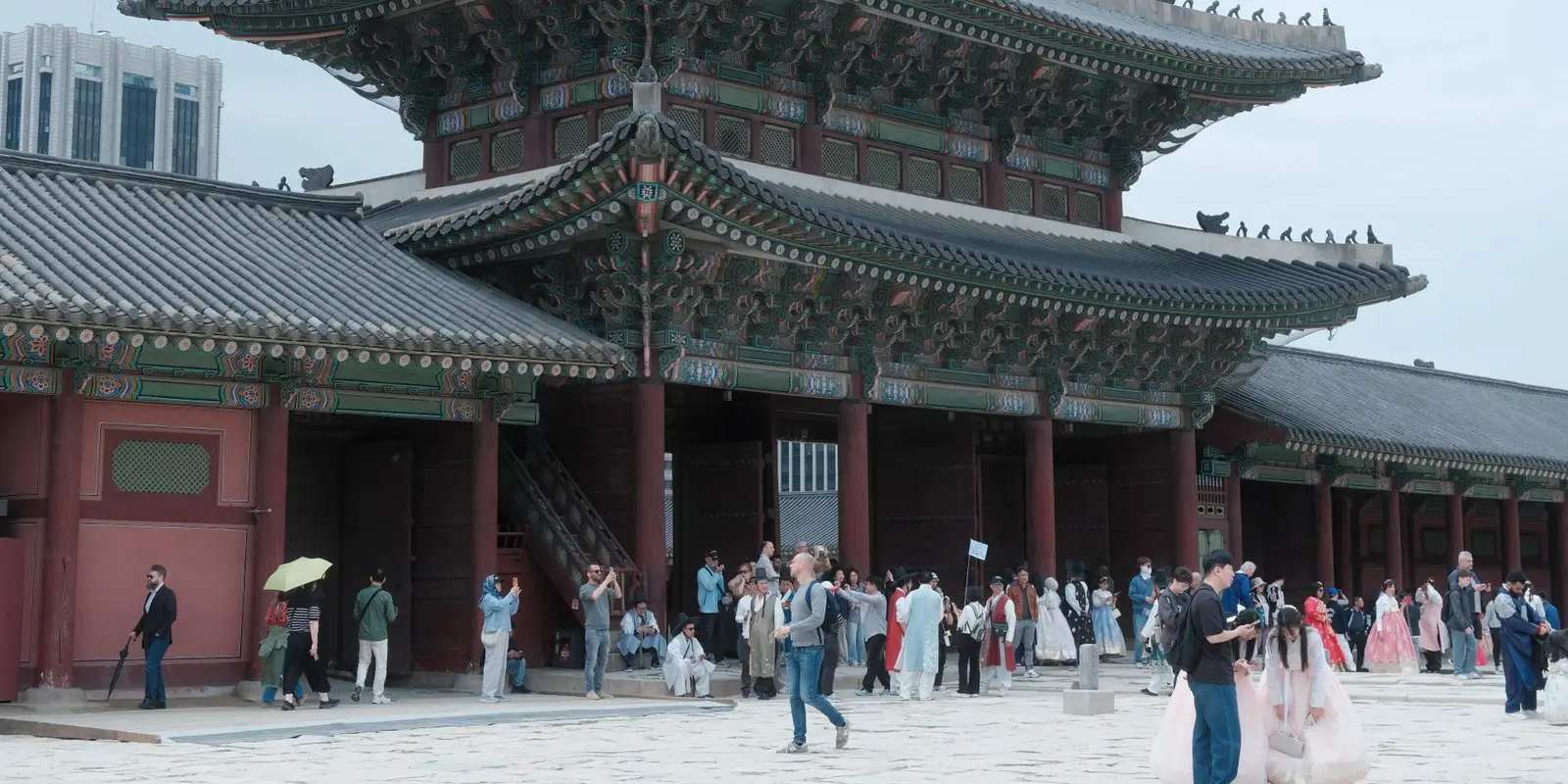 Visitors exploring Gyeongbokgung Palace in Seoul, South Korea, showcasing traditional architecture.
