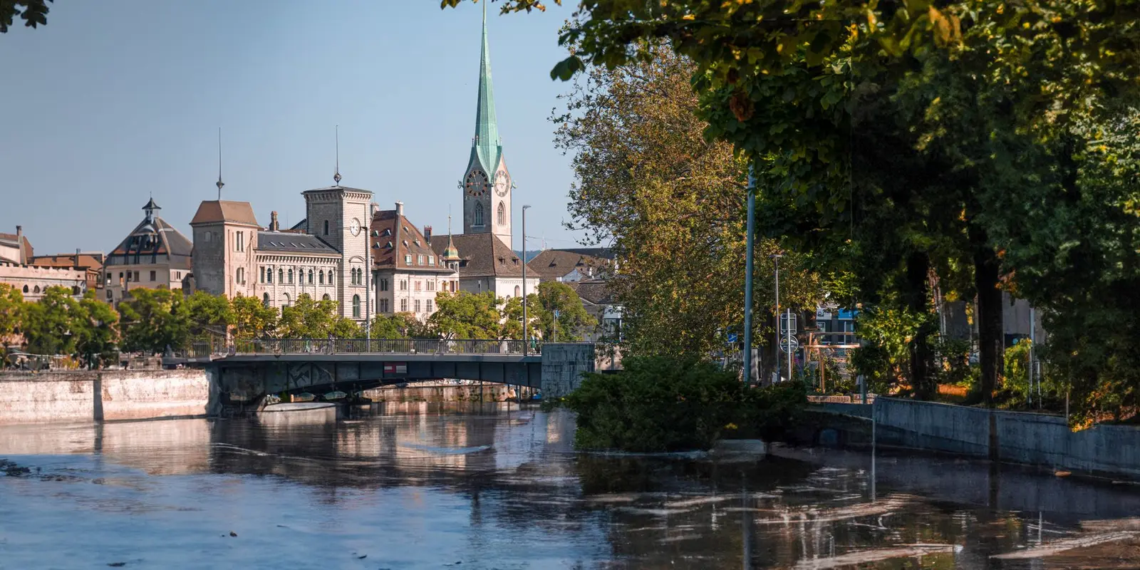 Beautiful view of Zurich, Switzerland, featuring Fraumünster Church and Limmat River on a sunny day.