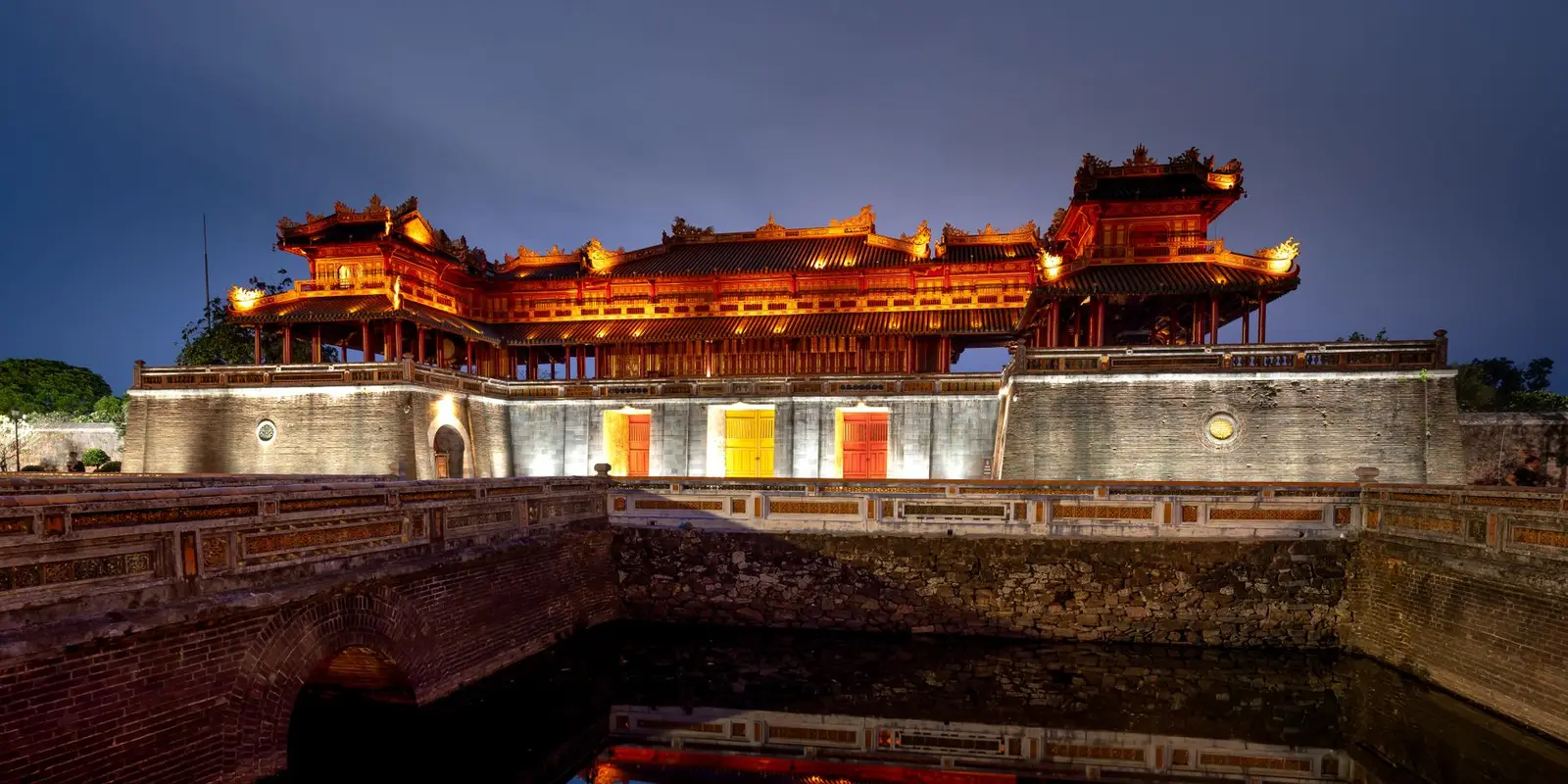 Stunning view of the Imperial City of Hue, Vietnam, reflected in calm waters at dusk.